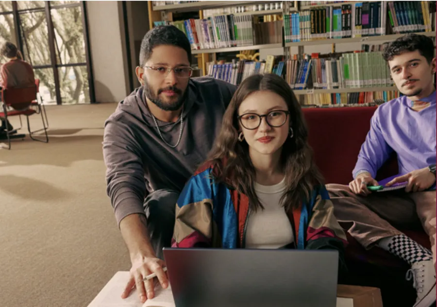 Estudantes da PUCPR trabalhando juntos em um projeto na biblioteca