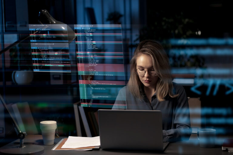 Mulher em frente ao computador com códigos de informática