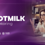 Mulher sentada em frente ao computador, recebendo mentoria online. Na arte está escrito HOTMILK Mentoring